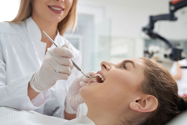 young woman getting her teeth examined at the dentist